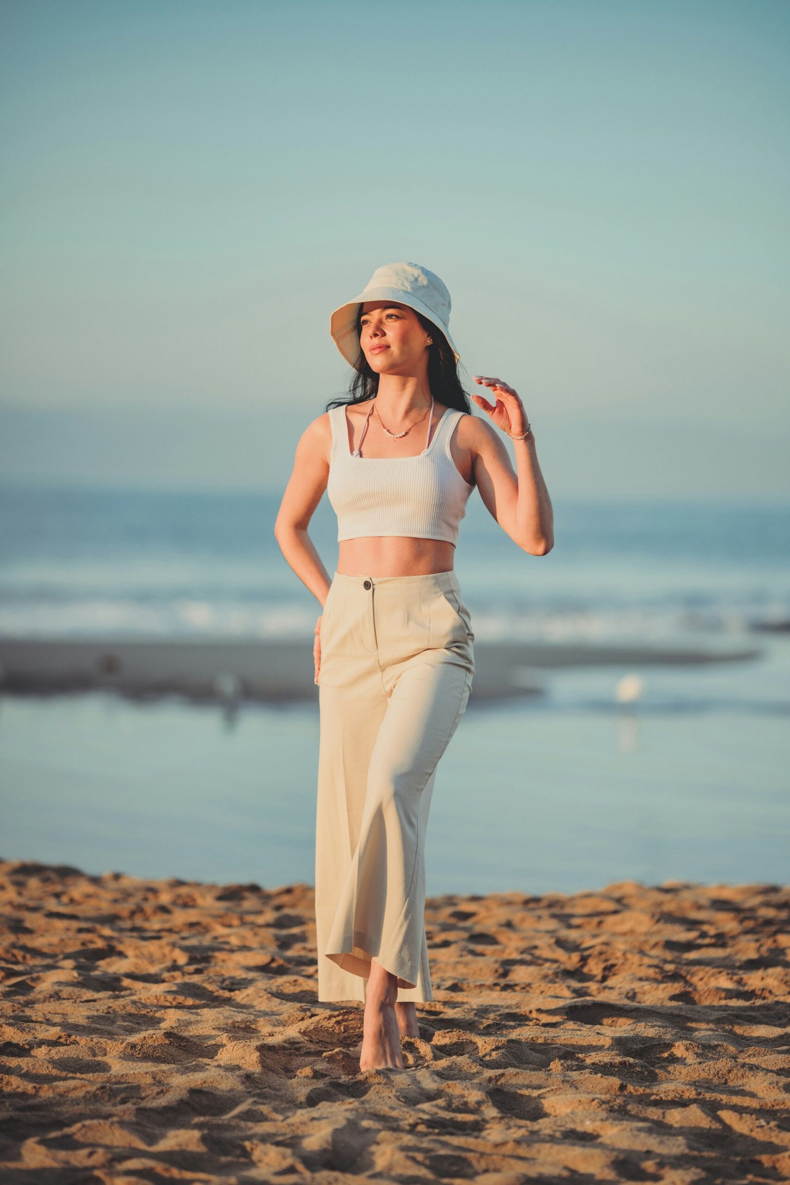 a woman standing on top of a sandy beach